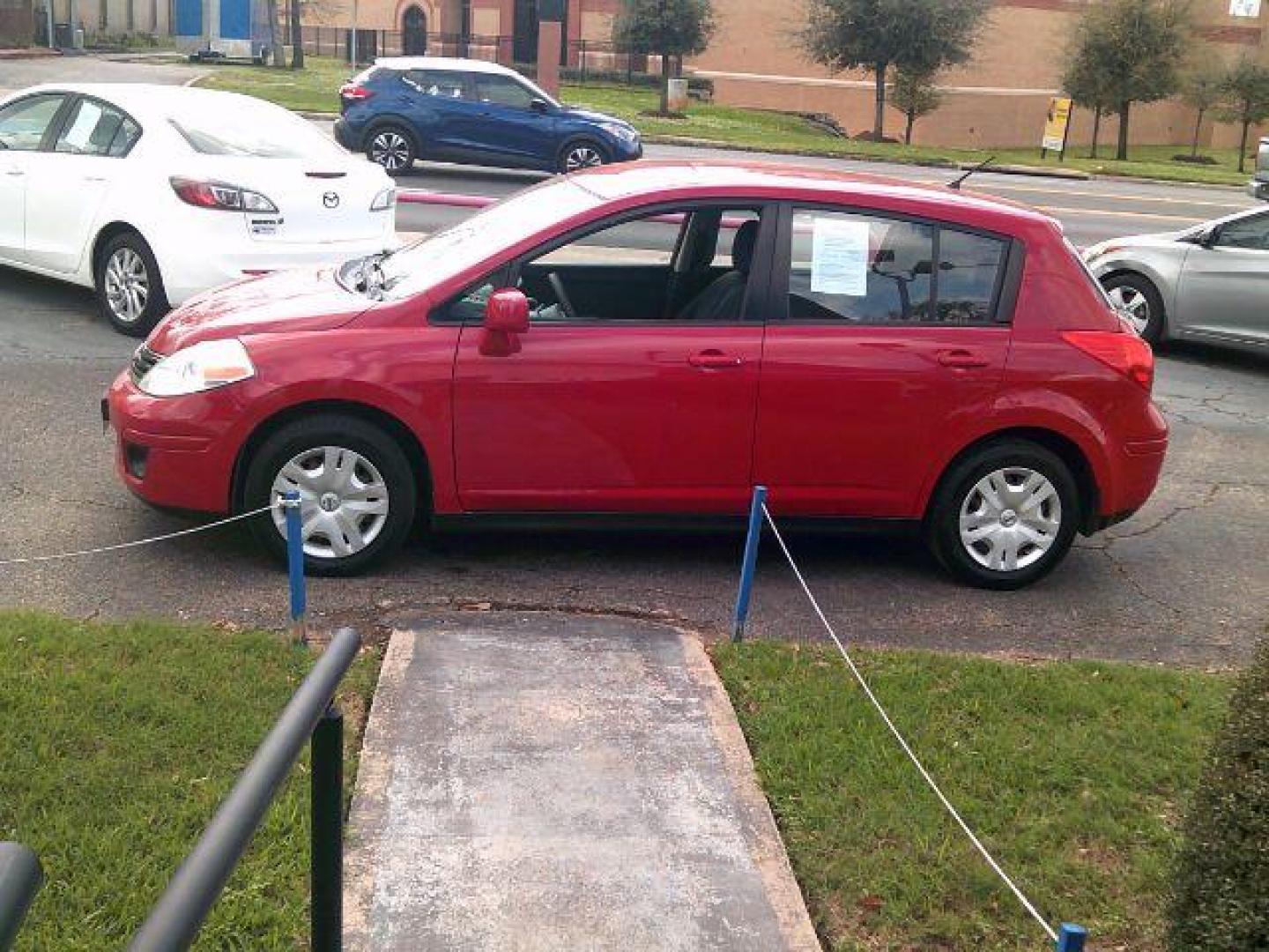 2012 Red Alert Metallic /Charcoal Nissan Versa 1.8 S (3N1BC1CP8CL) with an 1.8L I-4 DOHC engine, 5-Speed Automatic transmission, located at 116 N. Frazier Street, Conroe, TX, 77301, (936) 647-0690, 30.308662, -95.460480 - Photo#3